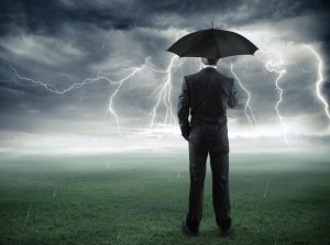 Business man holding umbrella as he stands outside during a thunder and lightning storm