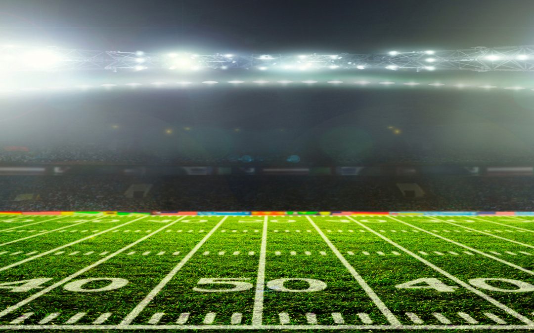 50 yard line of football field with night lights blazing